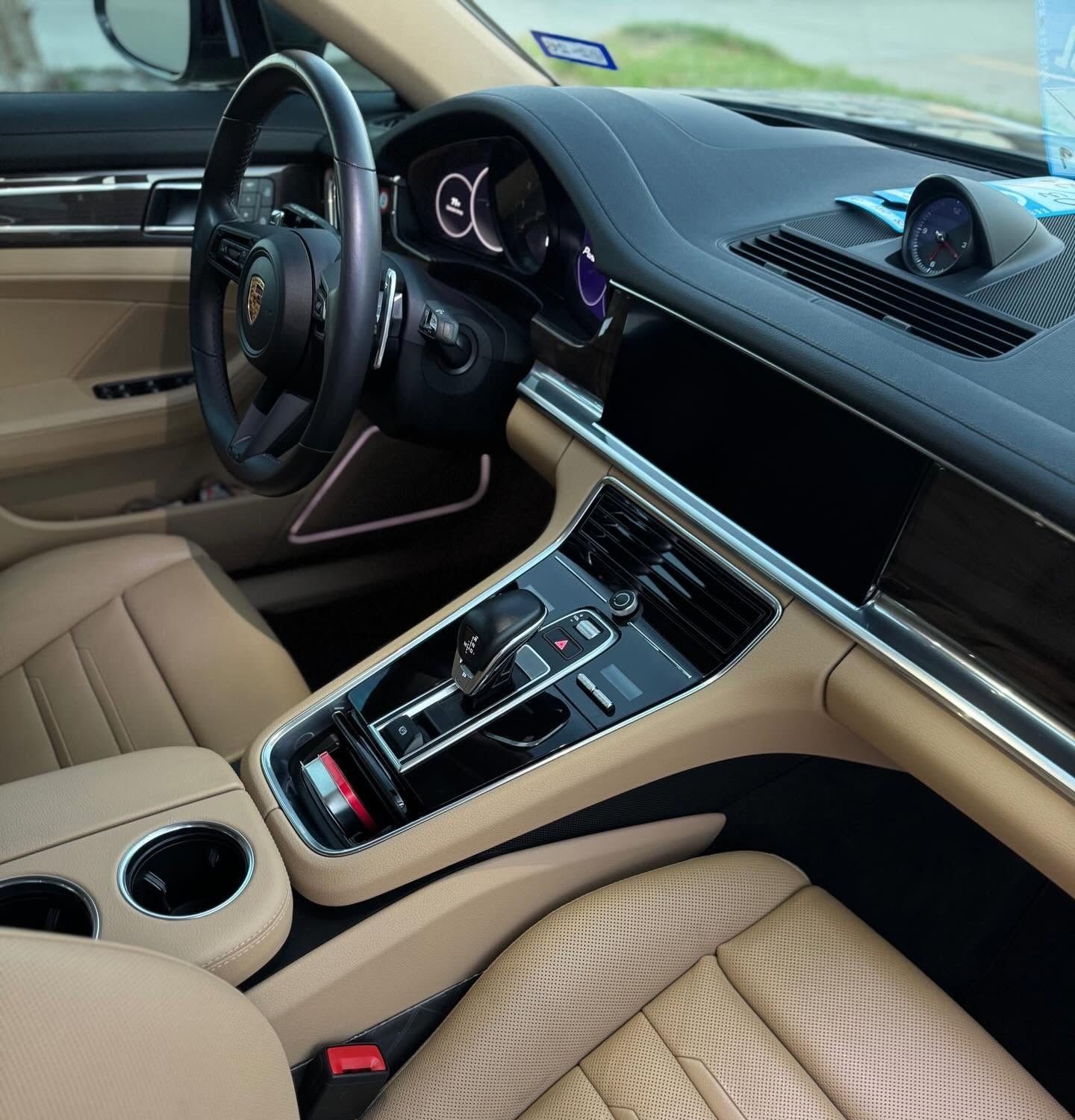 Open truck door showing black leather interior and dashboard under a bright blue sky