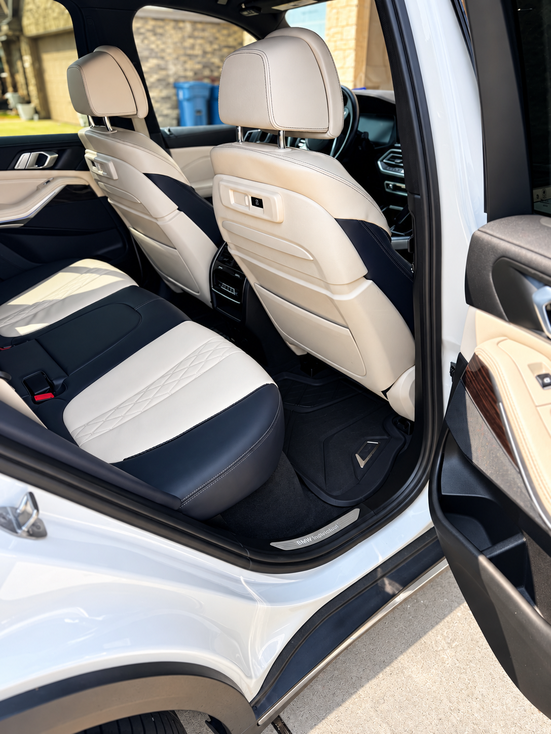 Open truck door showing black leather interior and dashboard under a bright blue sky