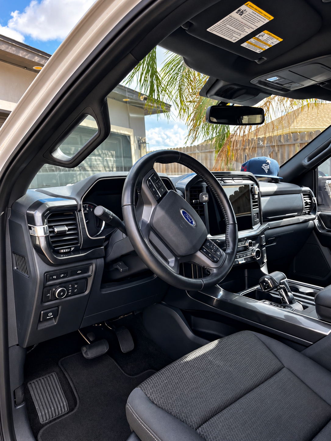 Interior of a black SUV, showing the driver’s seat, steering wheel, dashboard, and center console.