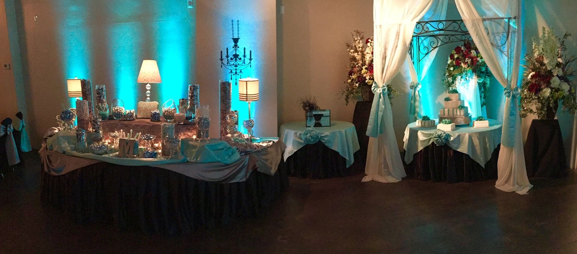 Decorated banquet hall with white chair covers, gold accents, and round tables set for an event