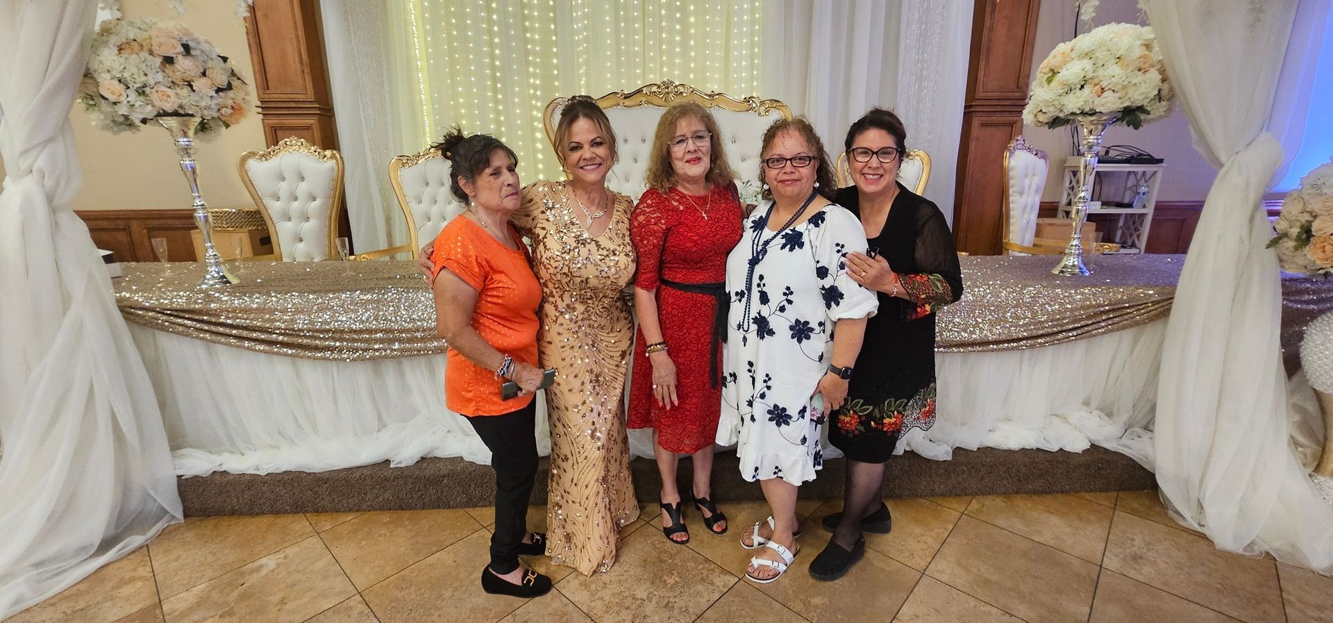 Five people posing in front of a decorated buffet table at a formal event