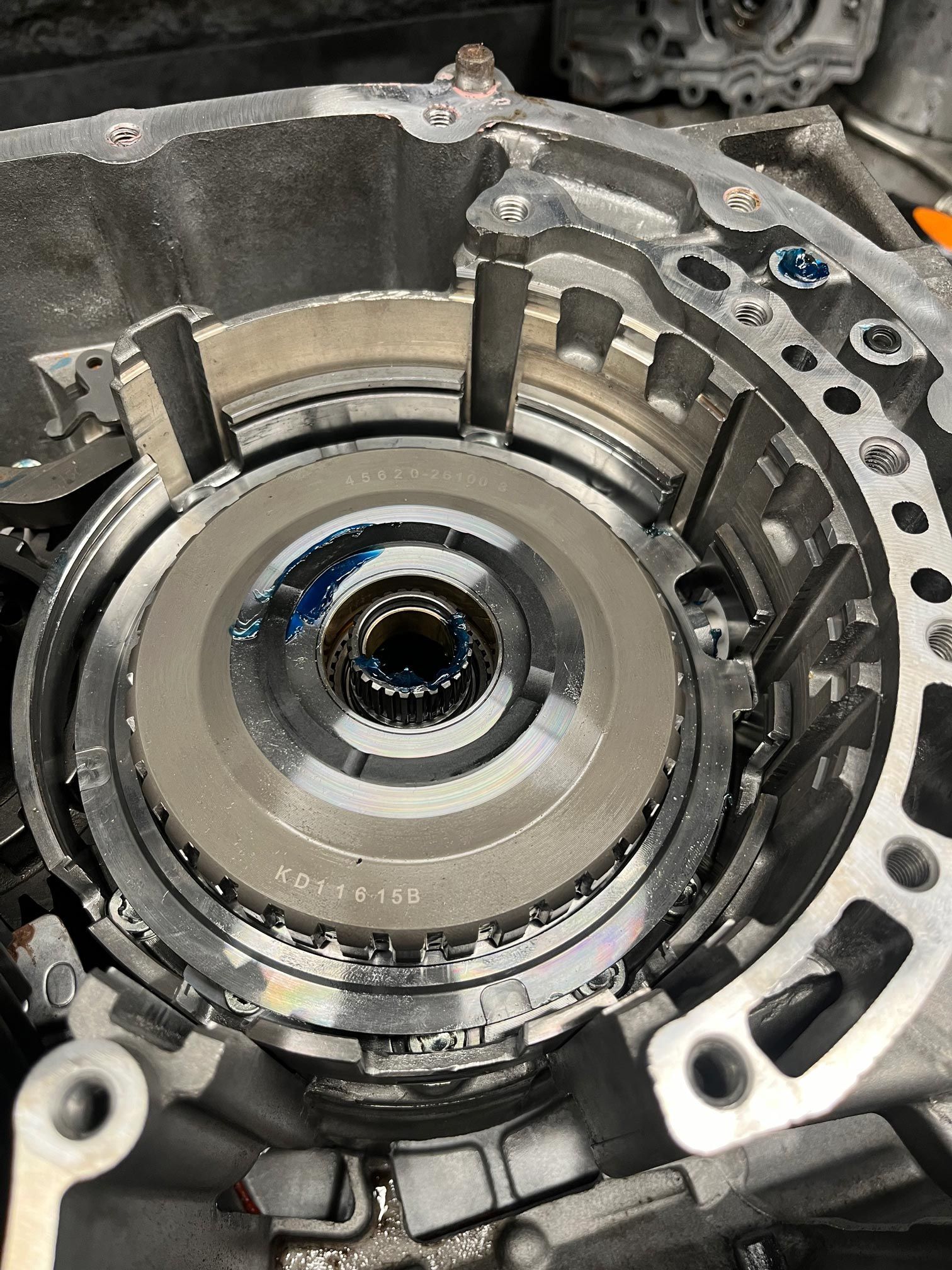 Inside of a transmission housing, showing clutch plates and gears. Metallic silver and grey.