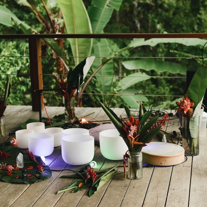 crystal sound healing bowls on deck with flowers and crystals