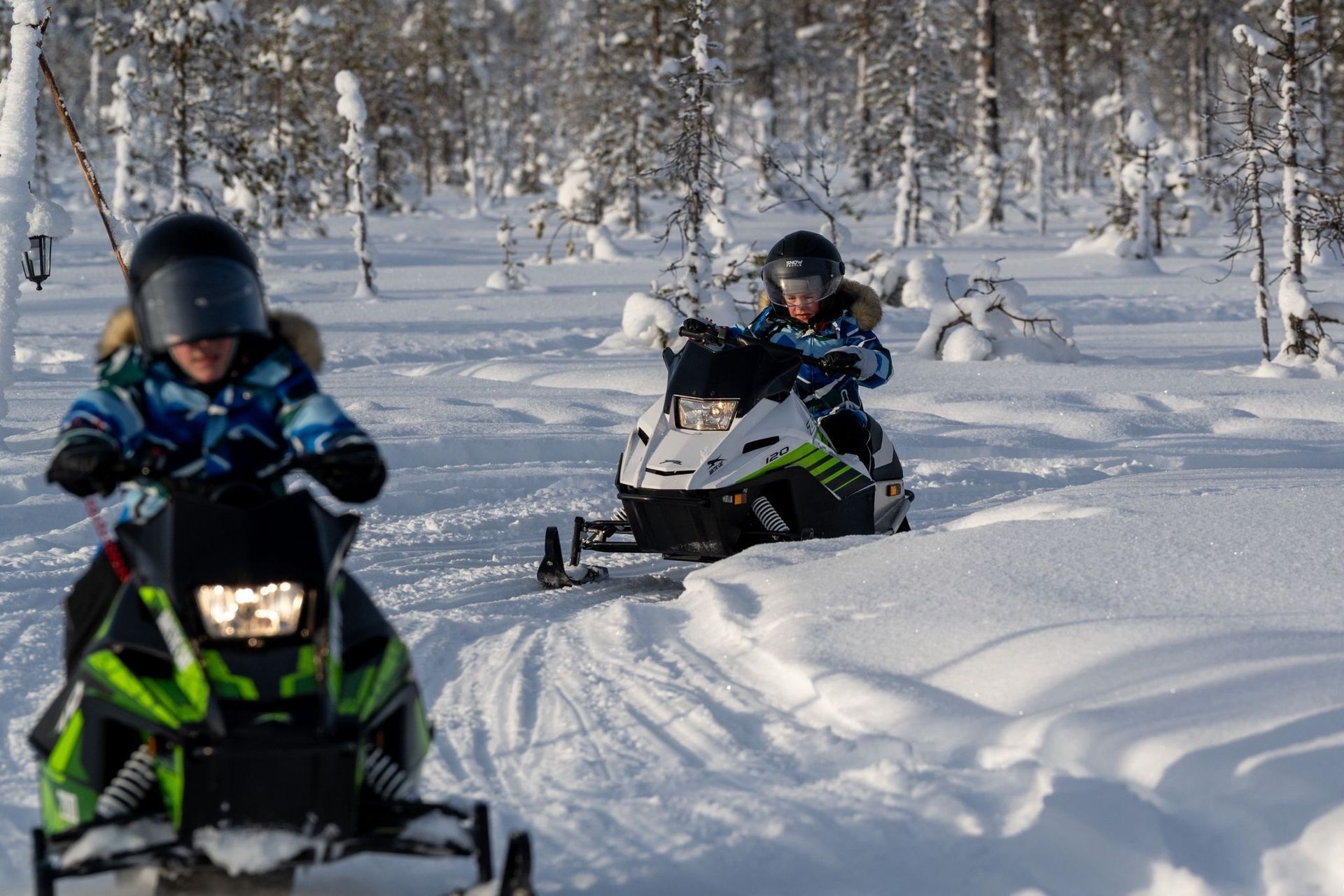 kids driving snowmobiles