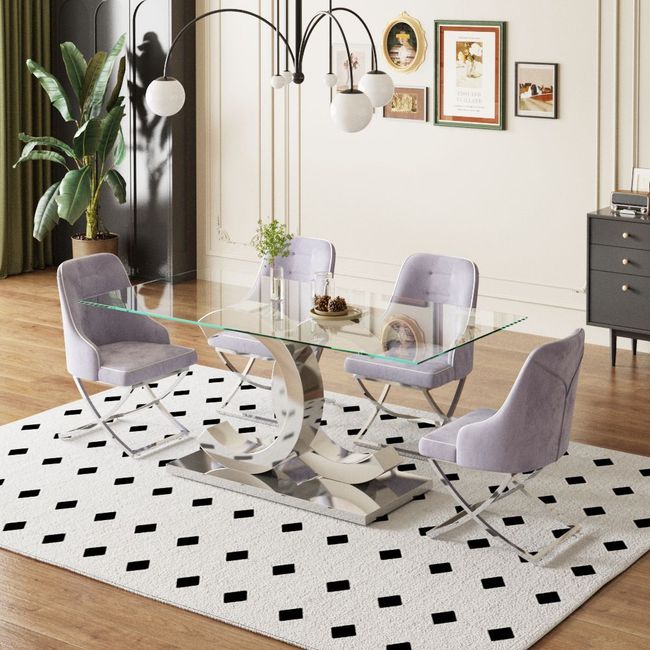 A dining room with a glass table and chairs on a rug.