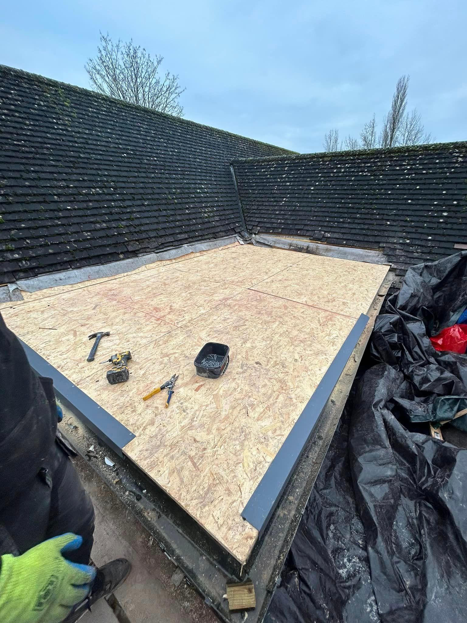 A person is working on a roof with tools on it.