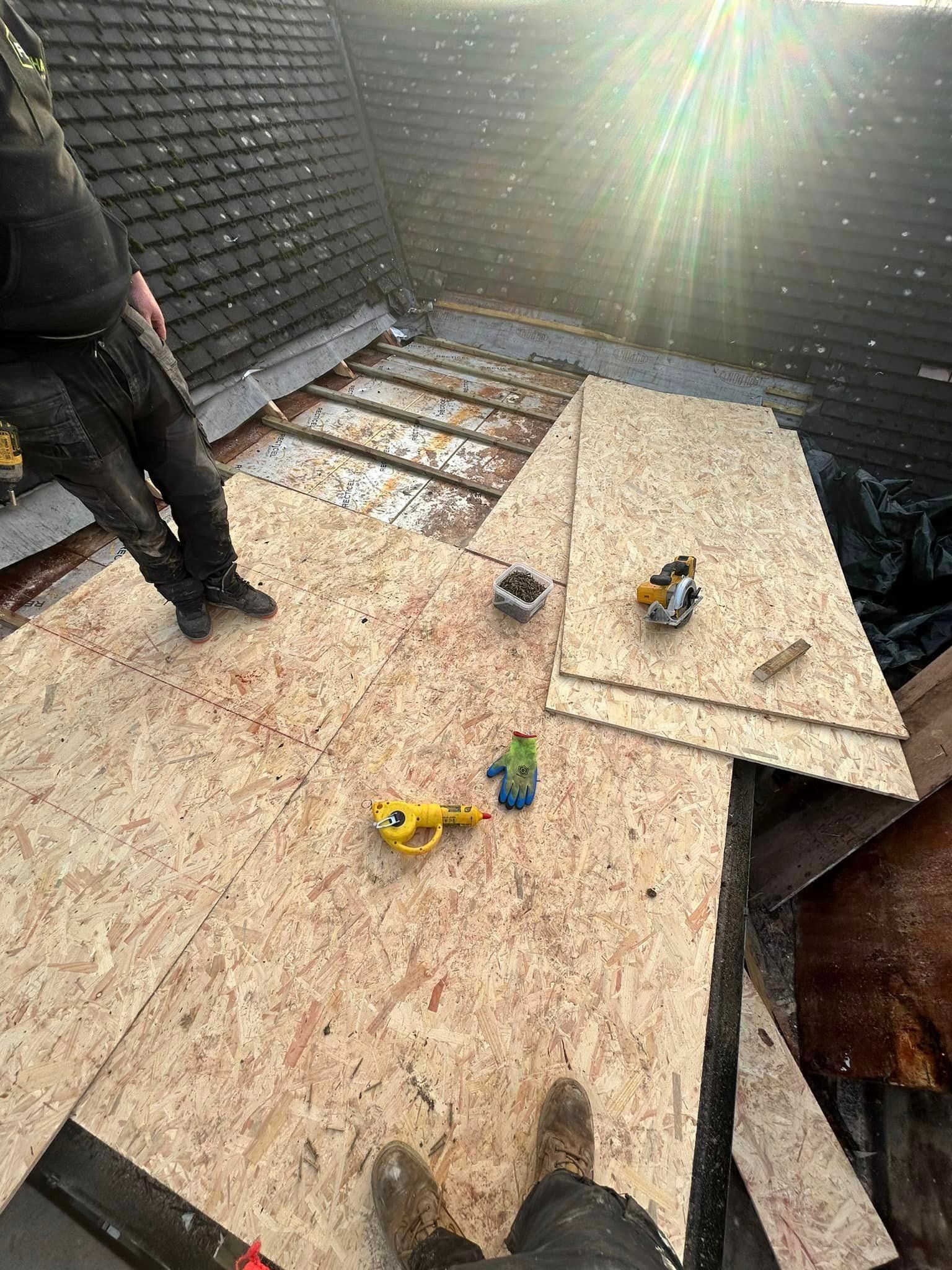 A person is standing on a wooden floor next to a brick wall.