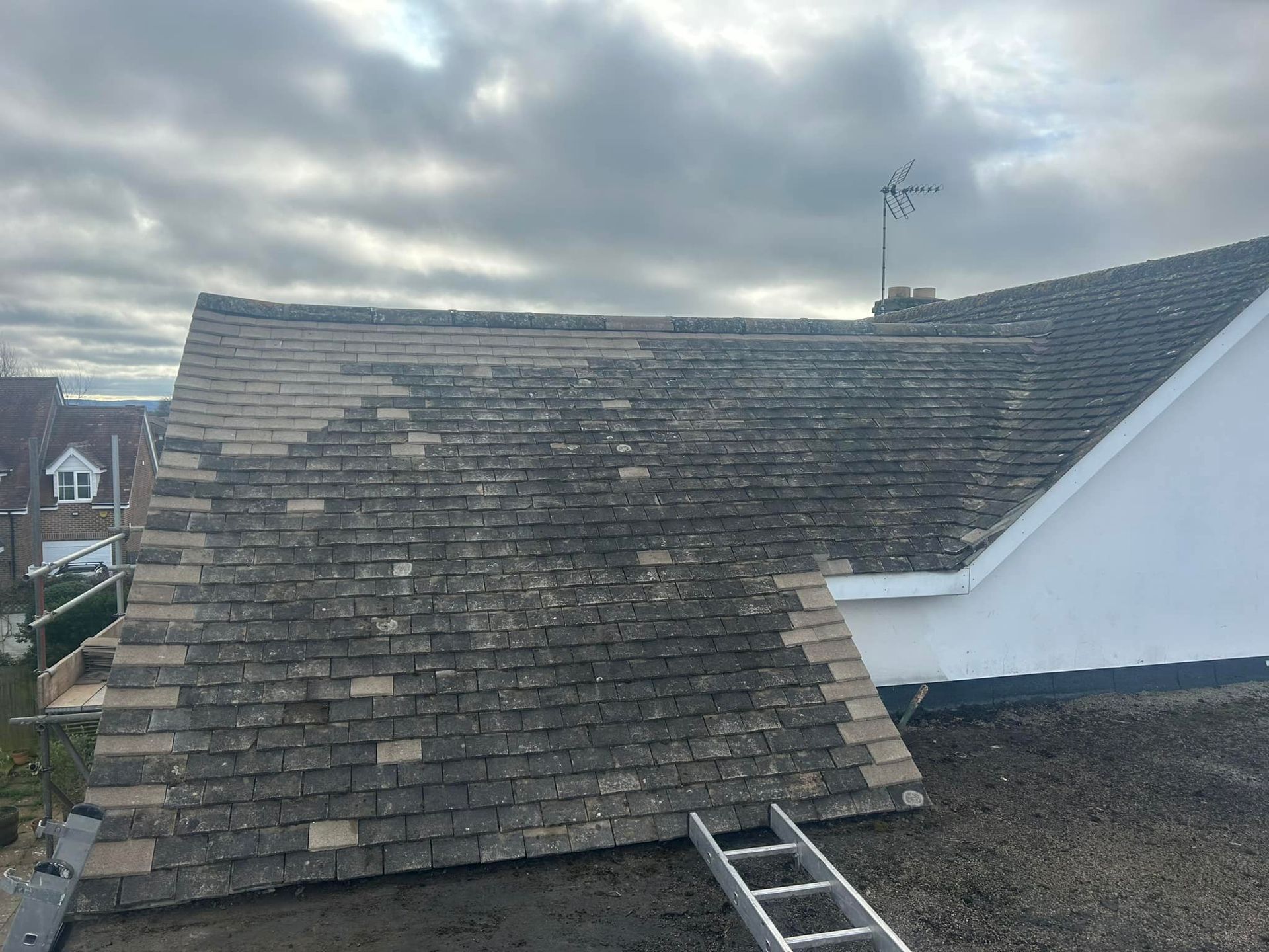 A ladder is sitting on the side of a roof.