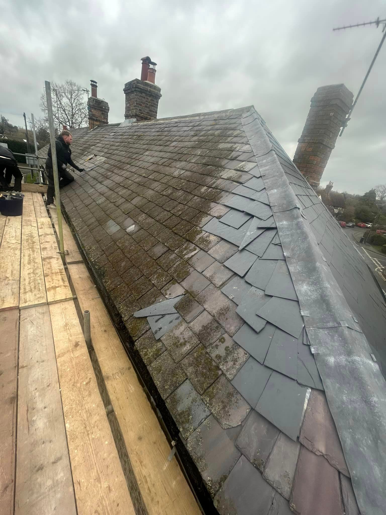 A man is sitting on the roof of a building.