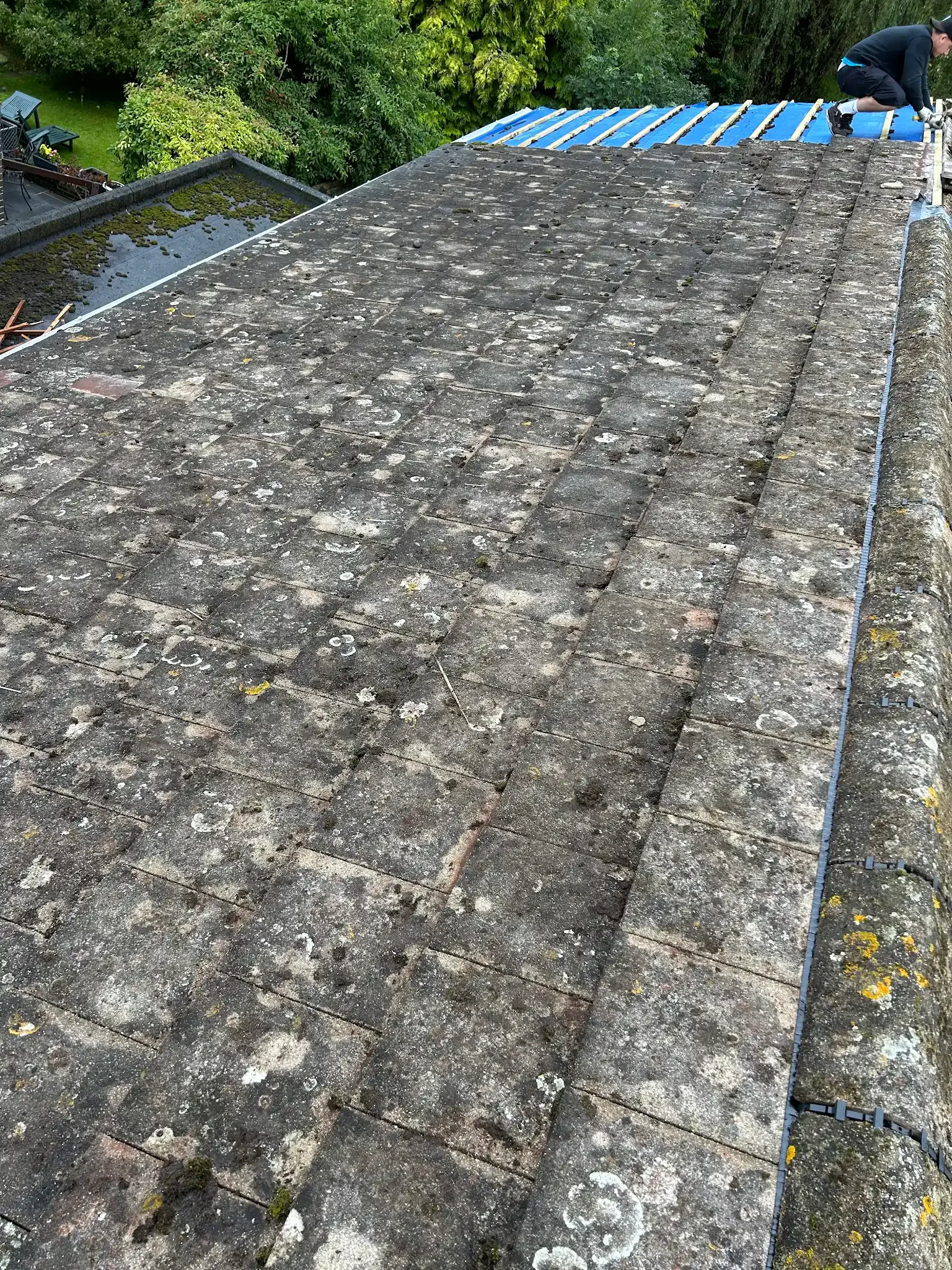 A man is working on the roof of a building.