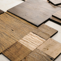 An assortment of various square wood veneer samples with different grains, textures, and brown tones laid on a white surface.