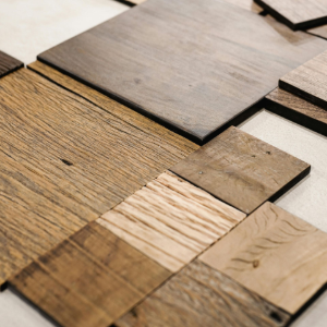 An assortment of various square wood veneer samples with different grains, textures, and brown tones laid on a white surface.