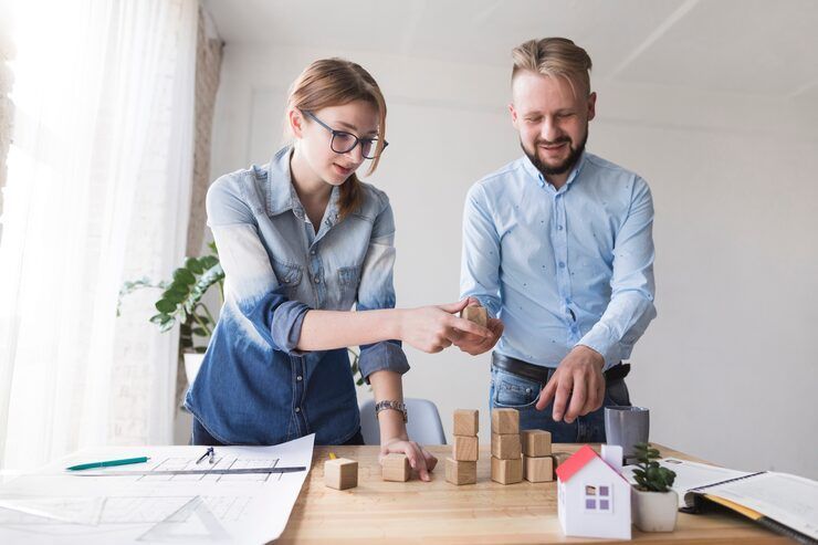 Two coworkers arranging wooden blocks on a desk in a bright office