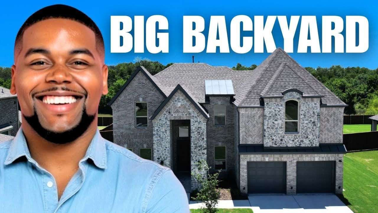 Smiling man beside a large gray modern house with bold text “BIG BACKYARD” in the sky-blue background