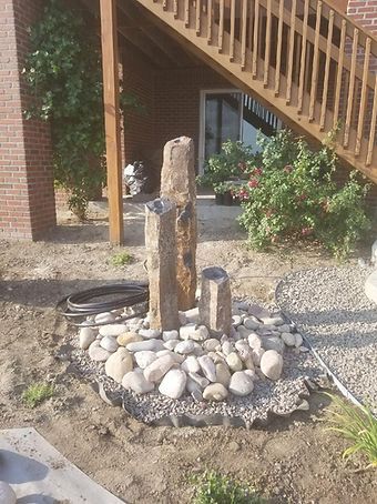 A Fountain is Sitting in the Dirt in Front of a Staircase