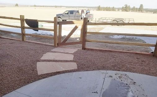A white truck is parked behind a wooden fence
