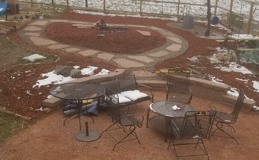 A patio with tables and chairs in the snow