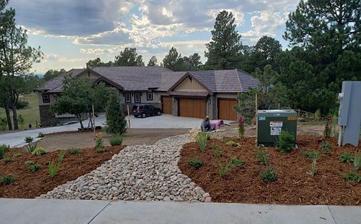 A large house with a car parked in front of it surrounded by trees.