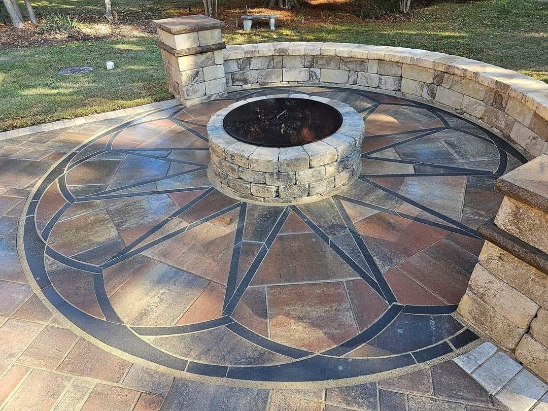 Stone patio with fire pit, featuring a circular design with brick and black accents.