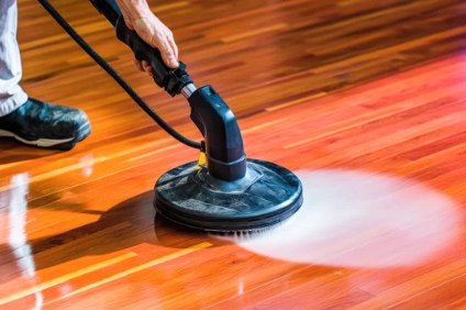 A wooden floor with a box of cleaning supplies on it.
