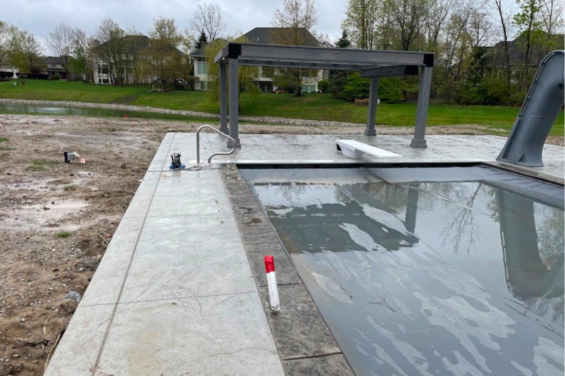 A swimming pool is being built in the middle of a dirt field