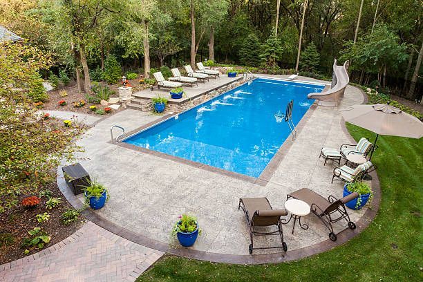There is a large swimming pool with a slide in the backyard