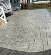 Stamped concrete patio with a rectangular stone pattern.