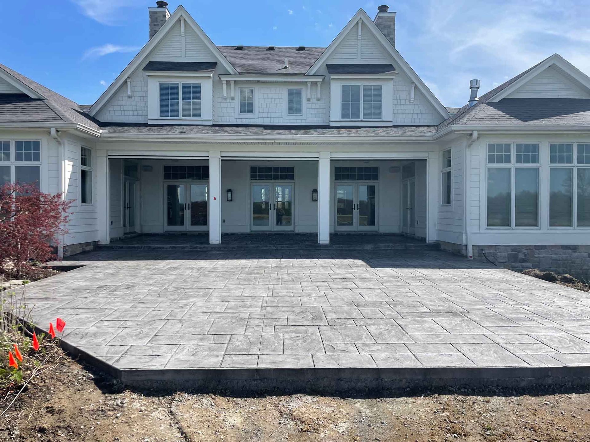 Front view of a large white house with a wide paved driveway and covered porch.