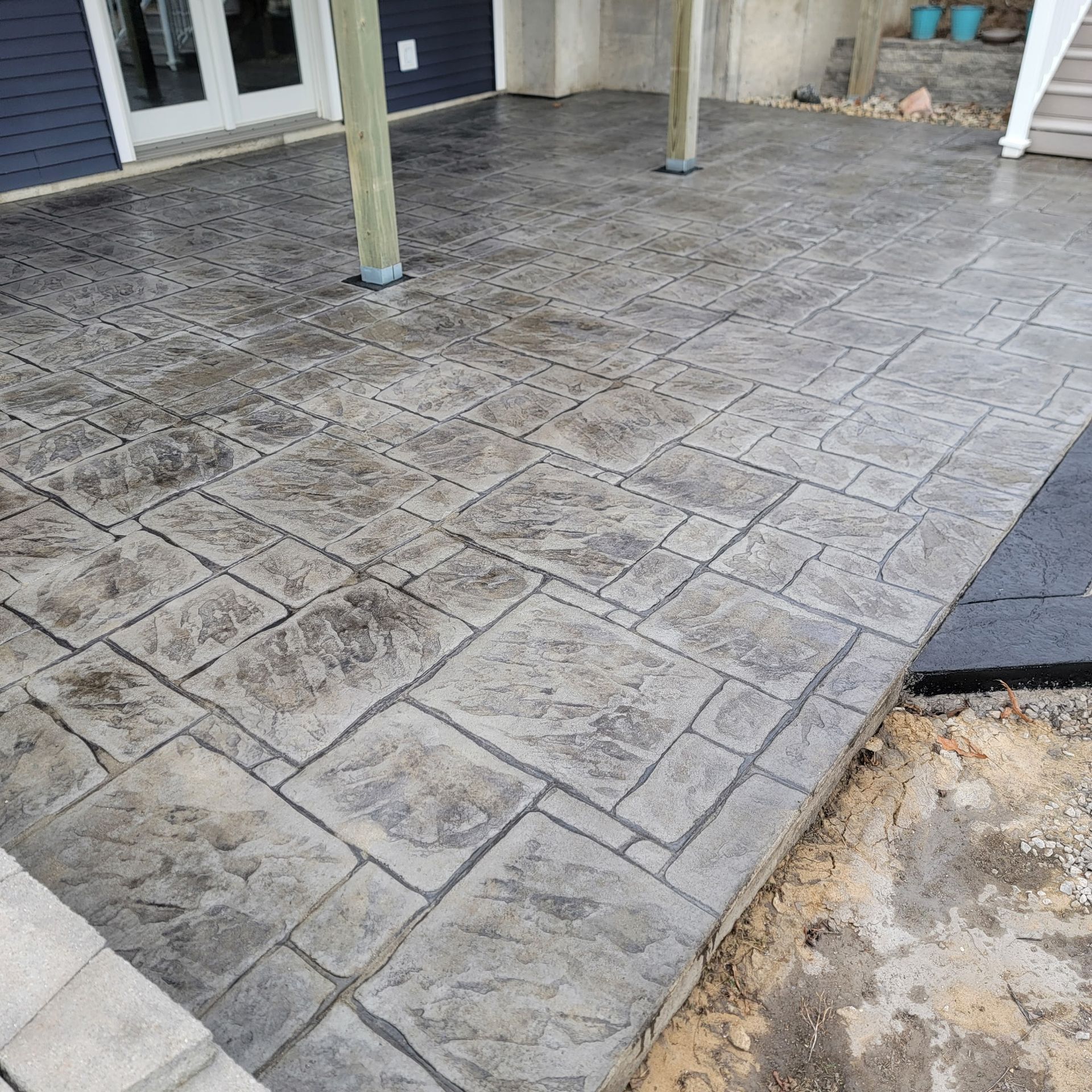 Stamped concrete patio in gray with a stone pattern.