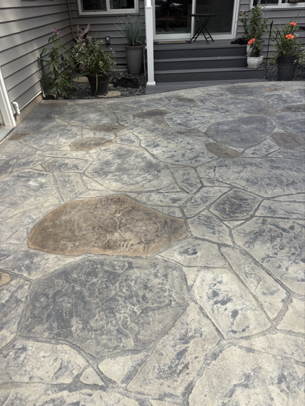 Cracked concrete driveway leading to a front porch with potted plants and steps