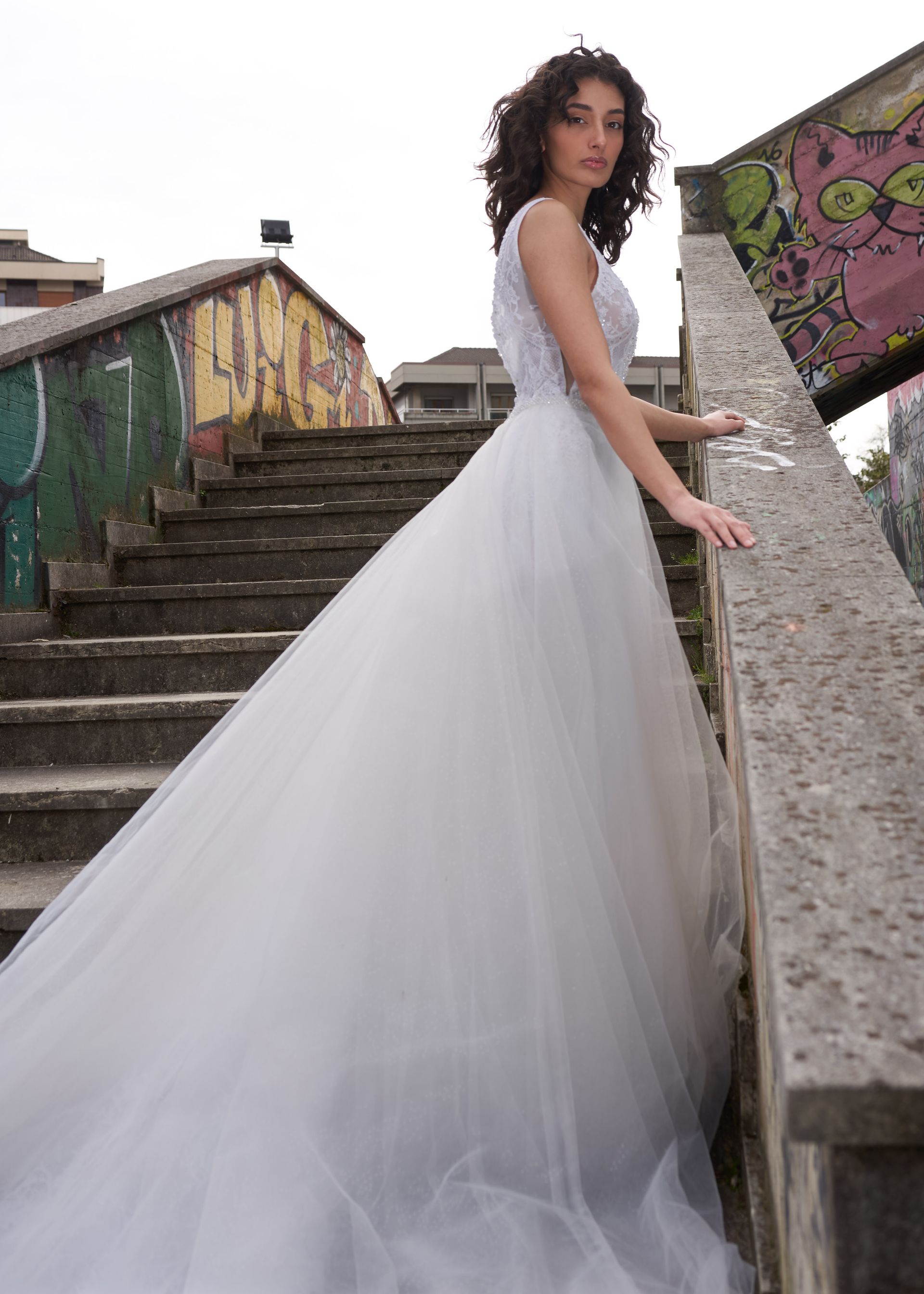 Una donna vestita di bianco è in piedi su una rampa di scale.