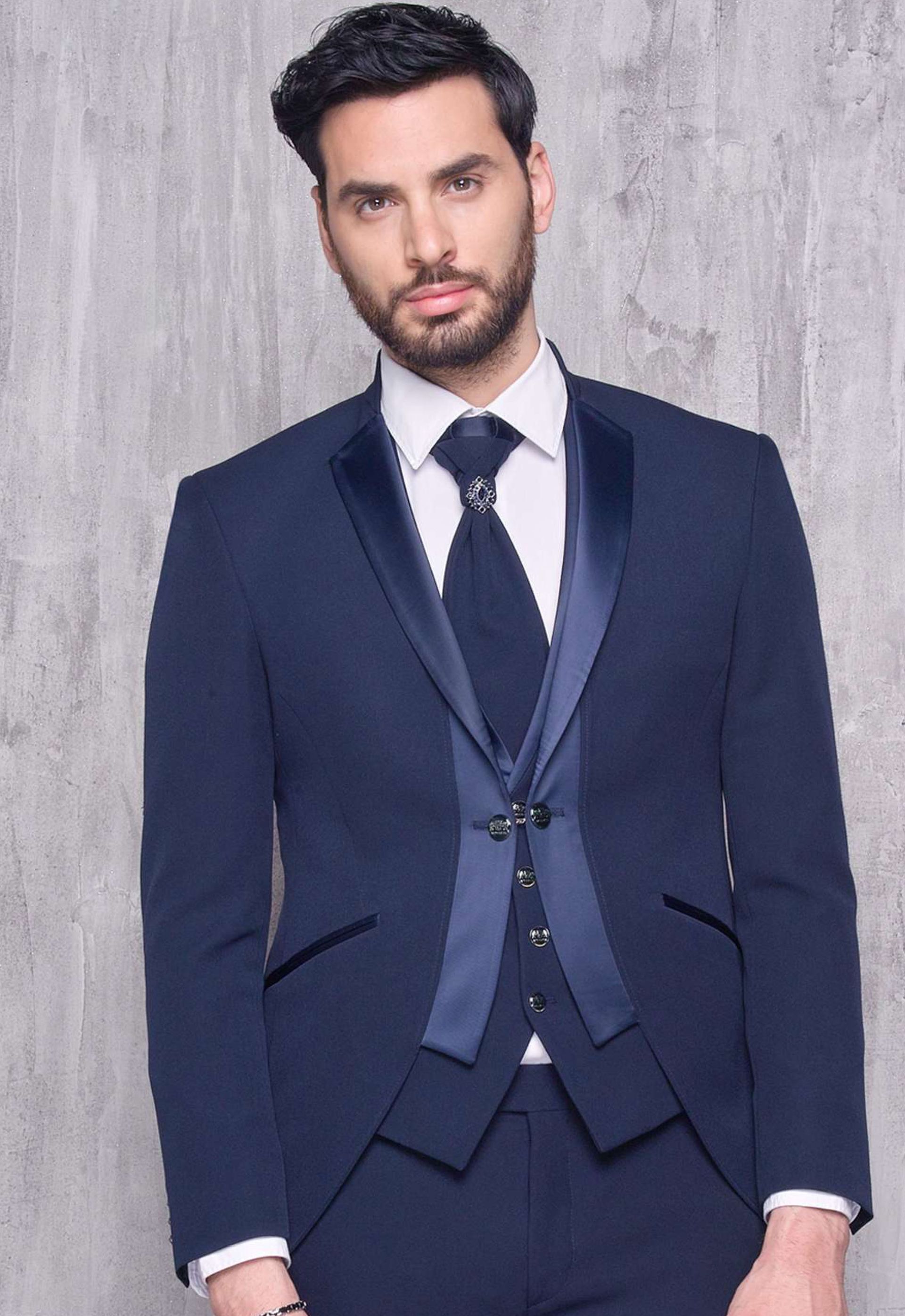 Un uomo indossa un abito blu e una cravatta