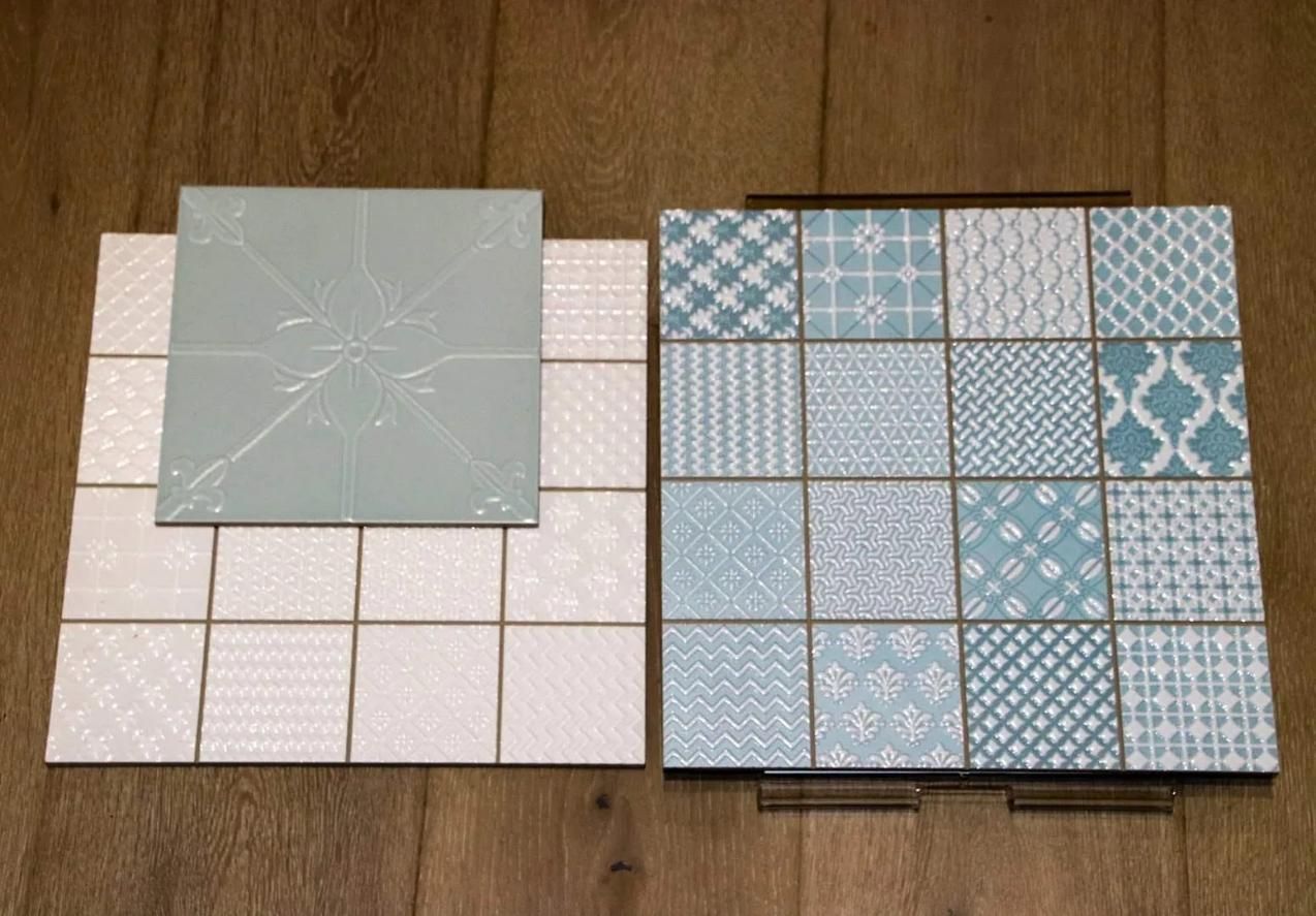 Two Tiles With Different Patterns Are Sitting on a Wooden Table — Traditional Tiles & Flooring in Smithfield, QLD