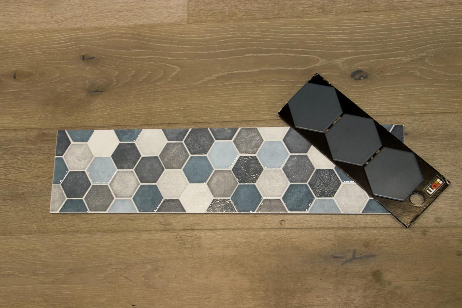 A Tile with A Hexagon Pattern Is Laying on A Wooden Floor — Traditional Tiles & Flooring In Woree, QLD