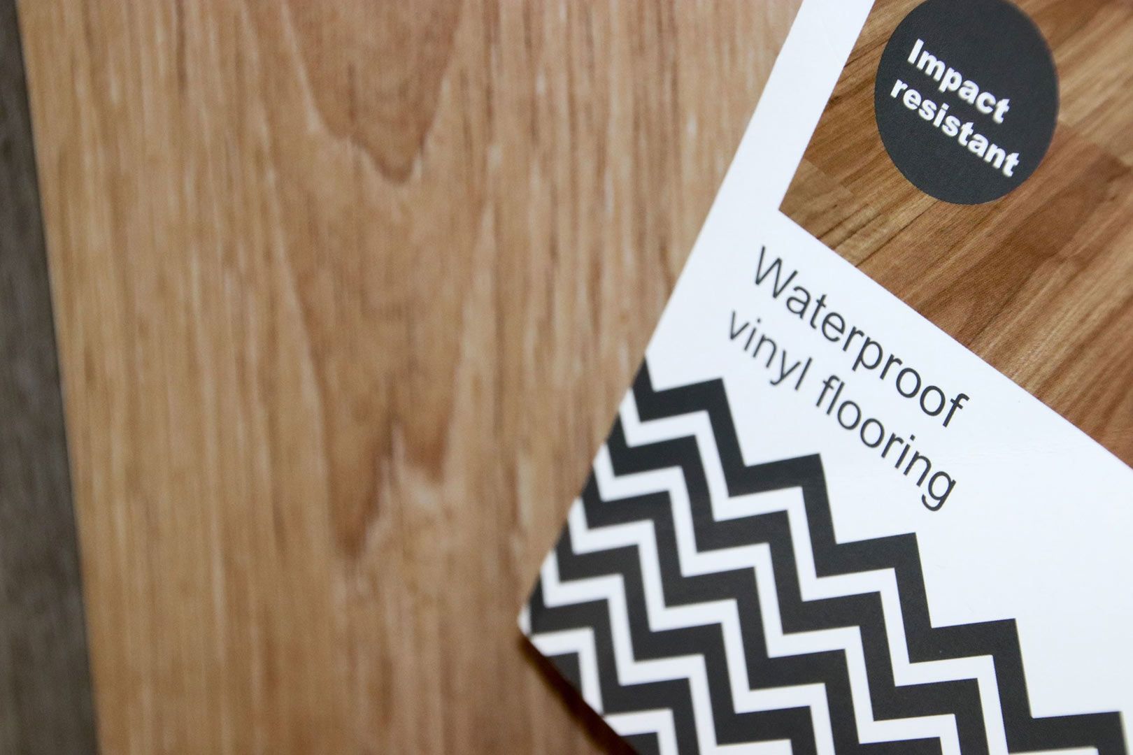 A Package of Waterproof Vinyl Flooring Is Sitting on A Wooden Table — Traditional Tiles & Flooring In Woree, QLD