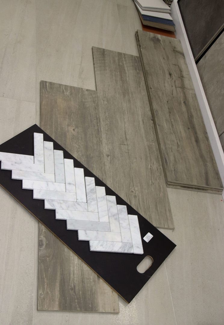 A Tray of Tiles Is Sitting on The Floor Next to A Stack of Tiles — Traditional Tiles & Flooring In Woree, QLD