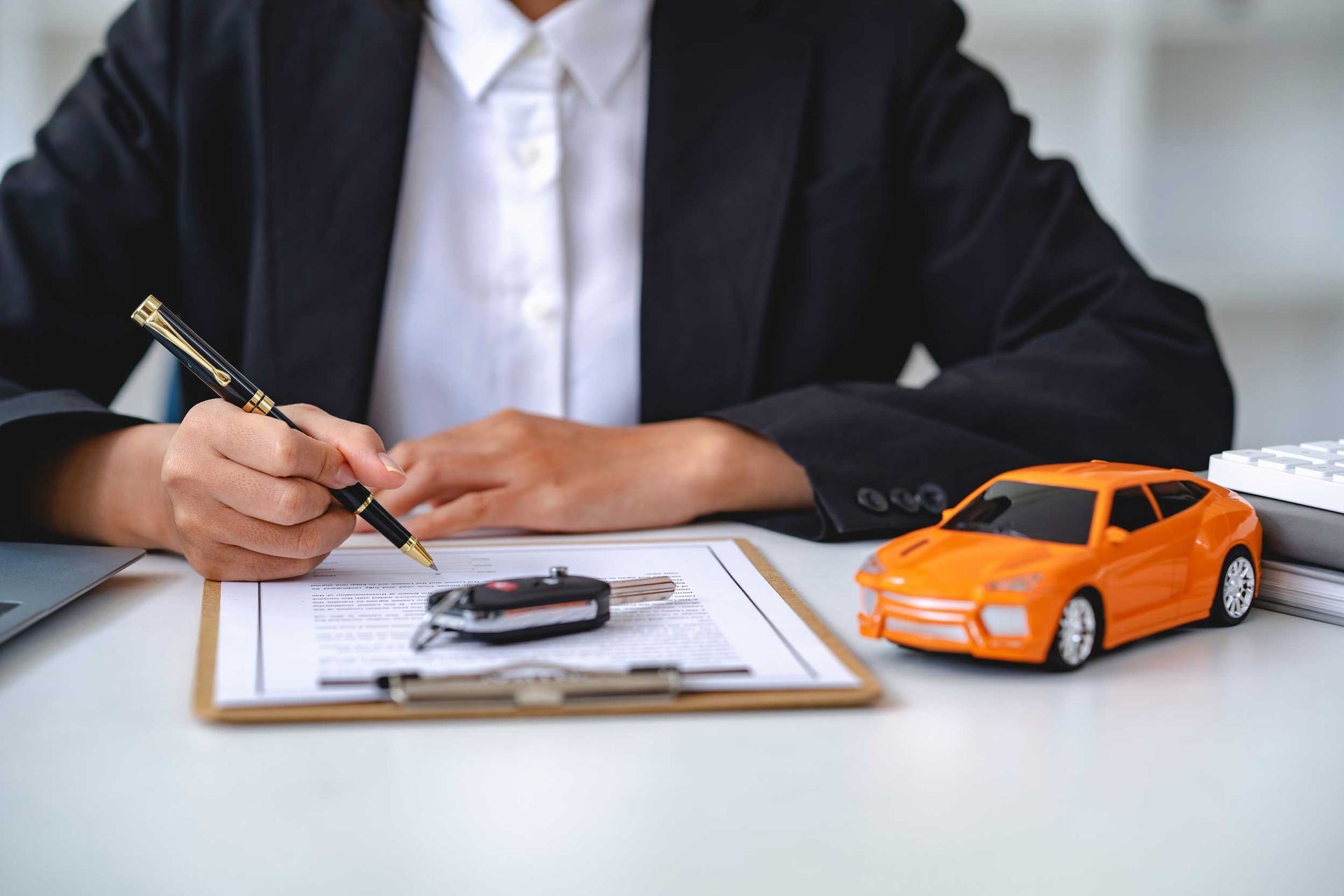Insurance officer’s hand over the car keys after the tenant has signed an auto insurance document. Insurance officer’s hand over the car keys after the tenant has signed an auto insurance document.