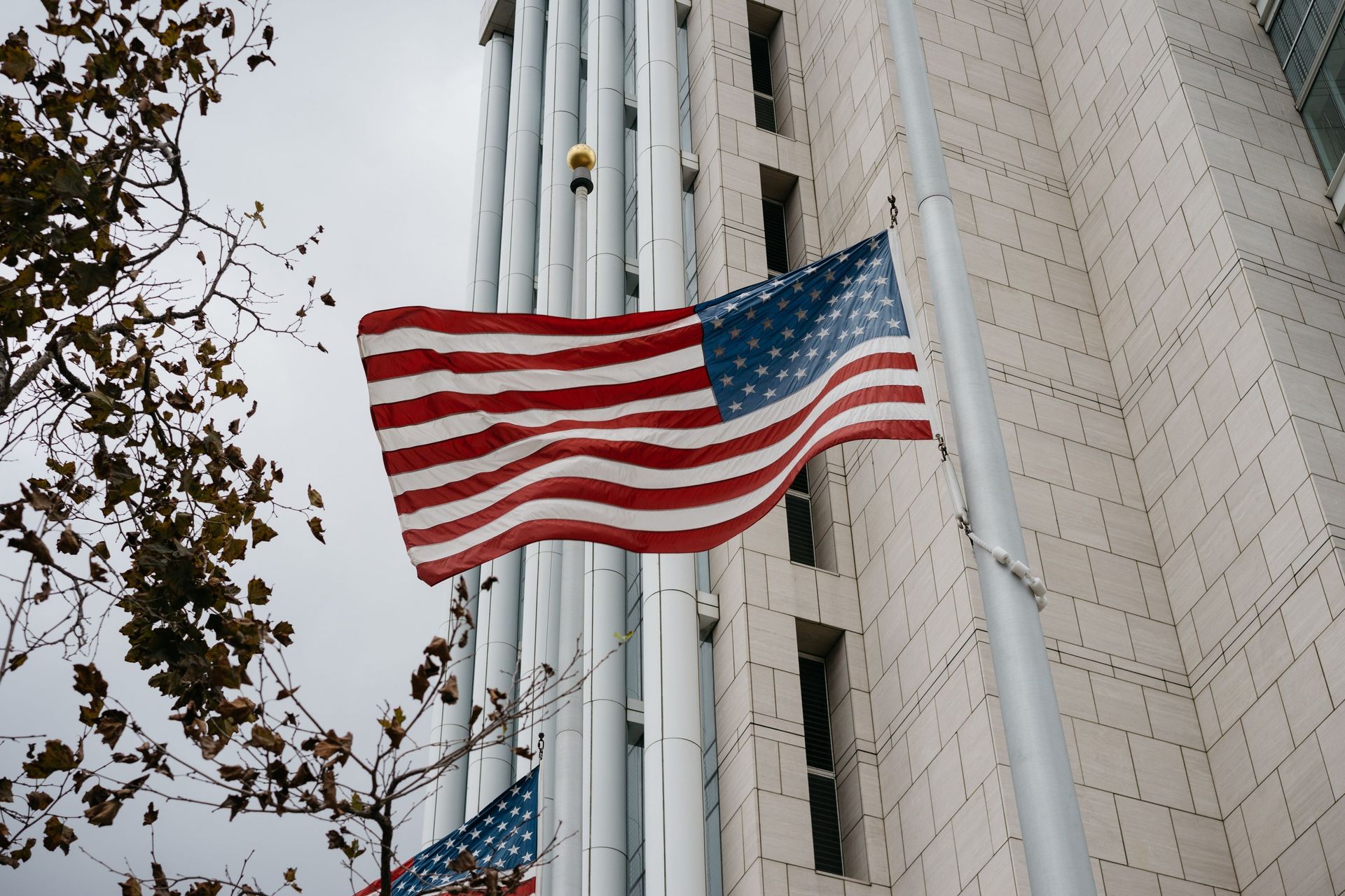 American flag waving outside a tall stone building