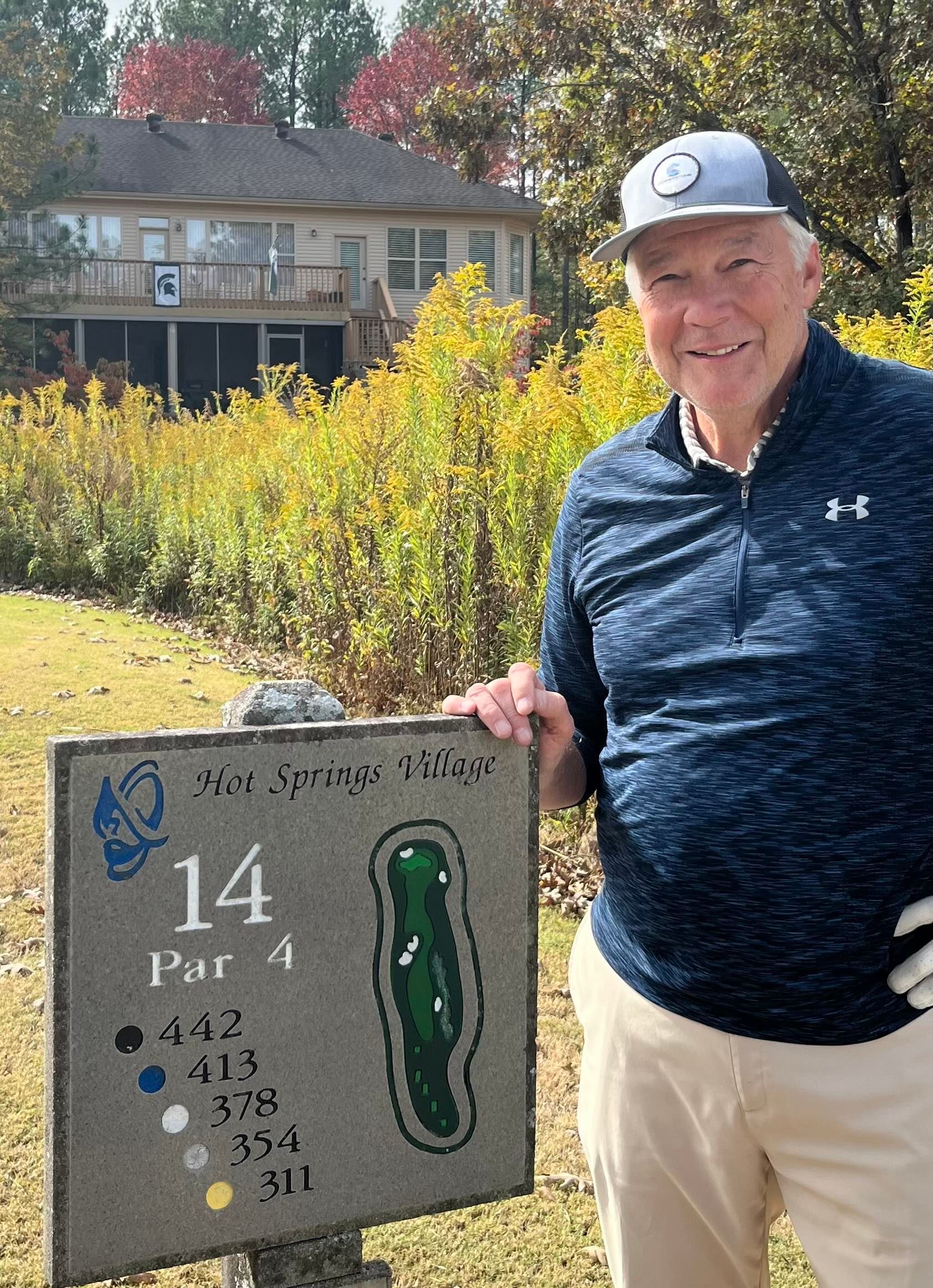 A man is holding a sign that says par 4 on it.