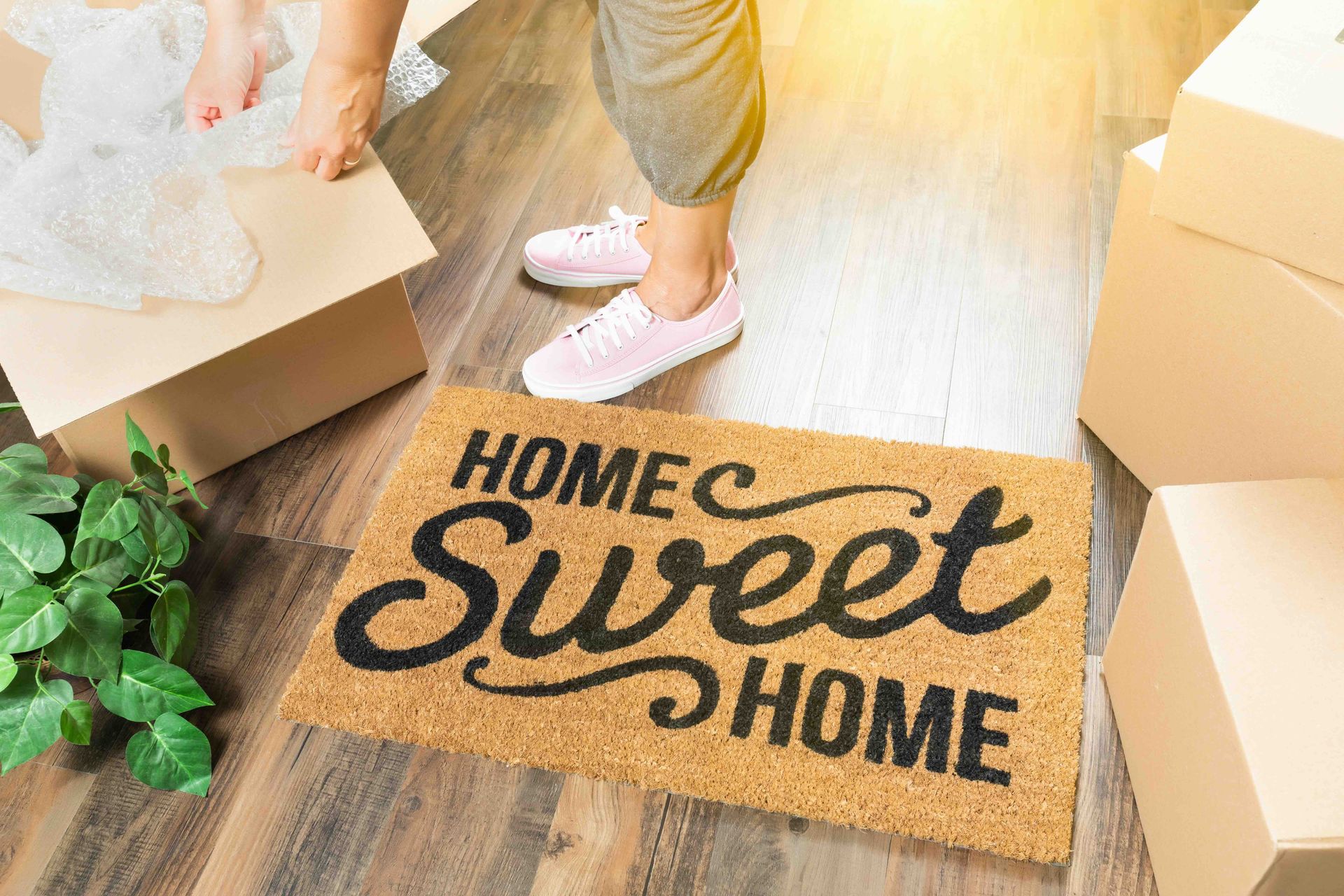 A person is standing next to a doormat that says