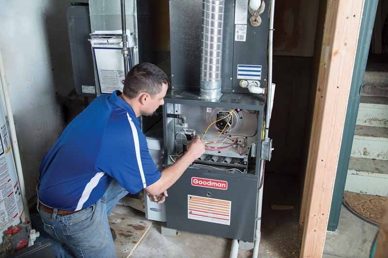 technician closing panel on furnace