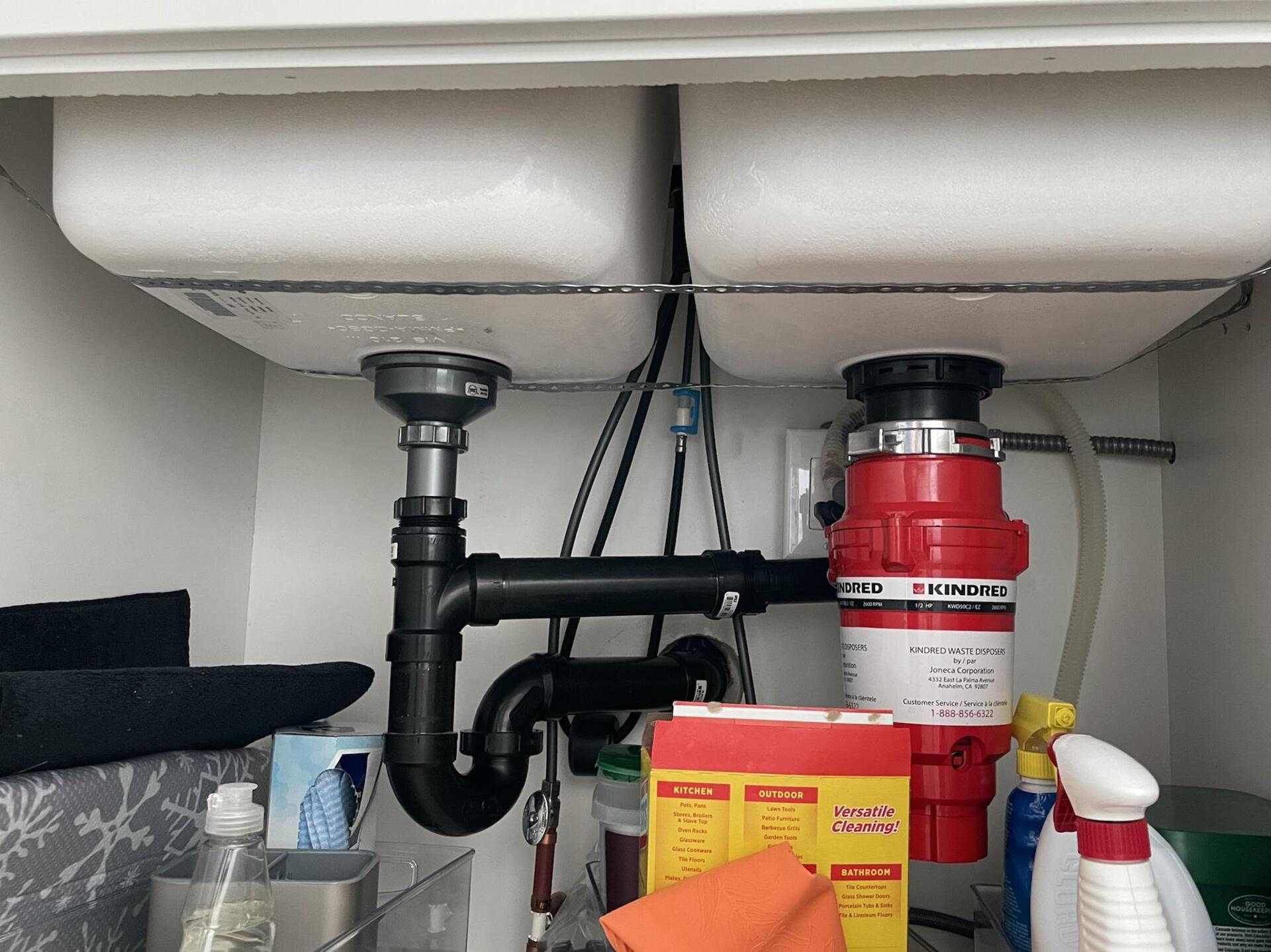 a plumber man fixing the kitchen sink disposal