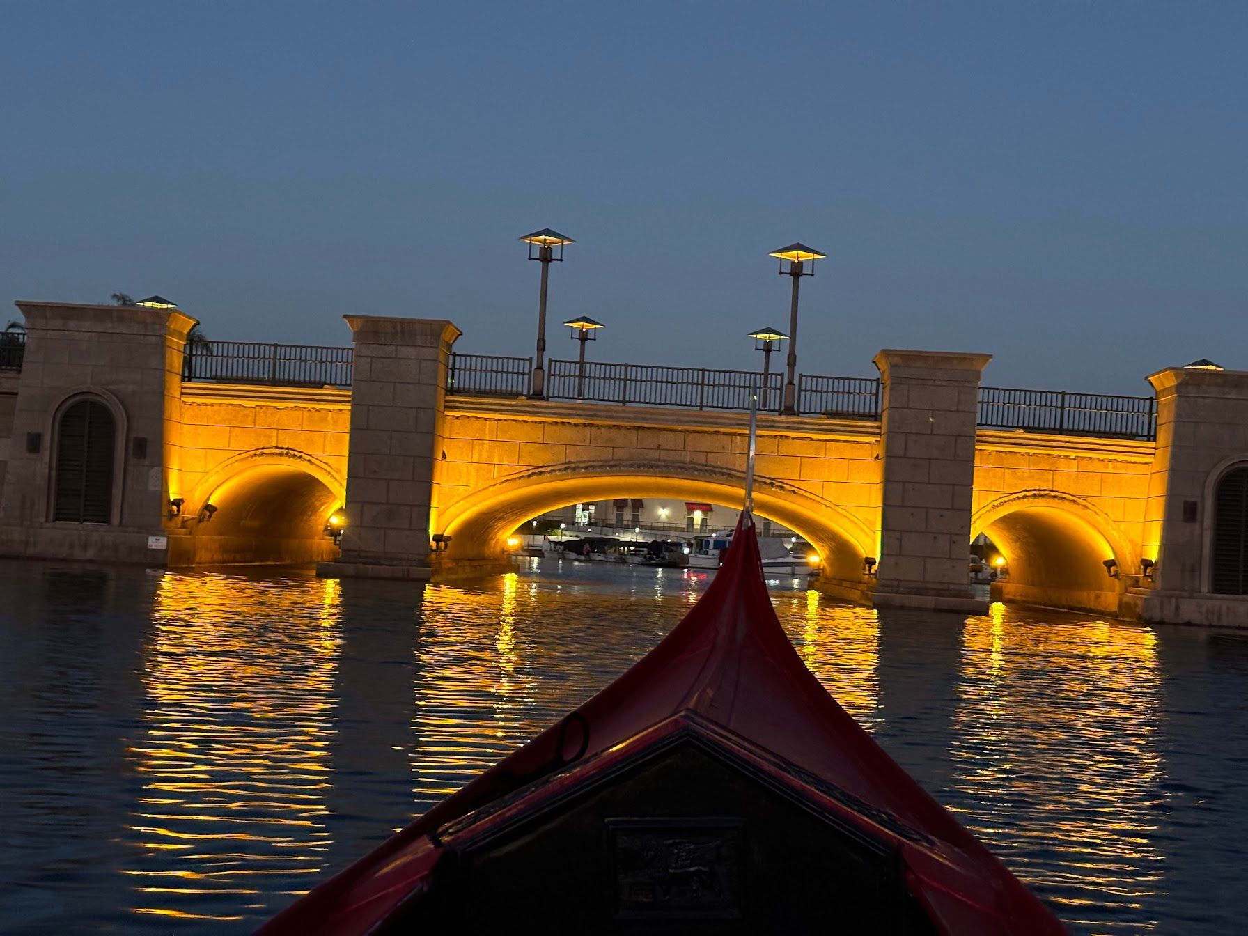 A bridge over a body of water is lit up at night