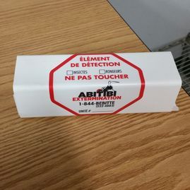 French pest control trap on wooden table, labeled “Ne pas toucher” and “Pest Extermination”