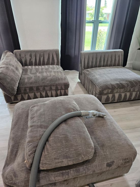 Gray textured lounge chairs and ottoman with a striped hose in a bright room by a window