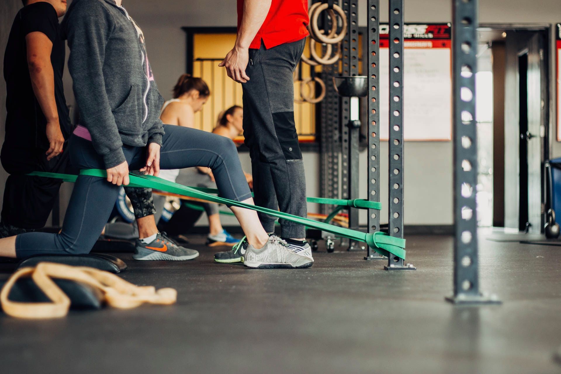 A group of people are doing stretching exercises in a gym.