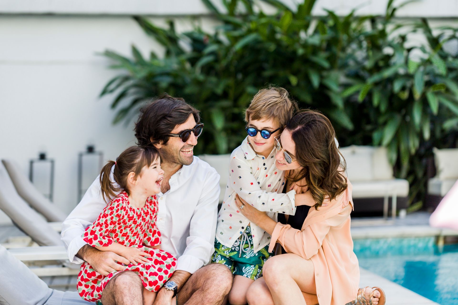 Una familia está sentada en el borde de una piscina.