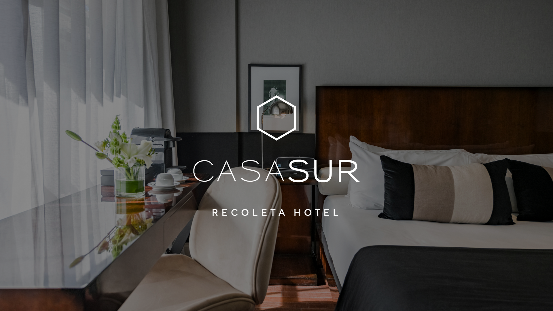 Una habitación de hotel con cama, escritorio y silla.