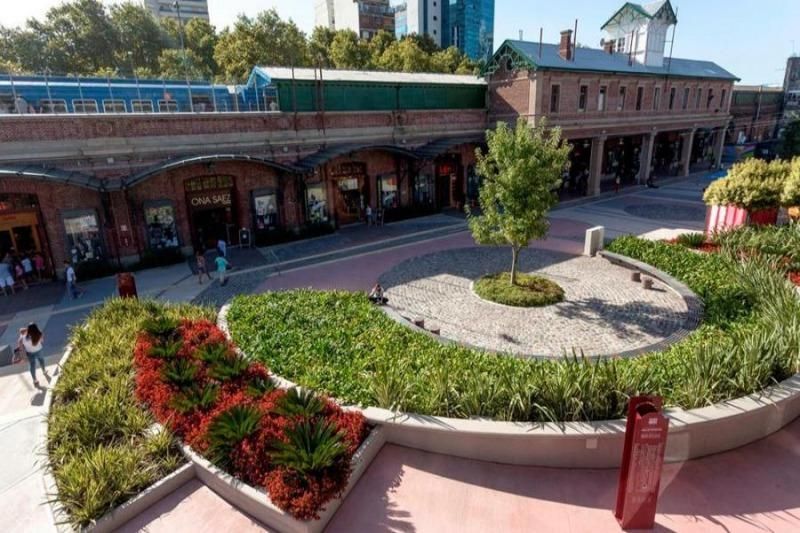 Una vista aérea de una estación de tren con un jardín circular frente a ella