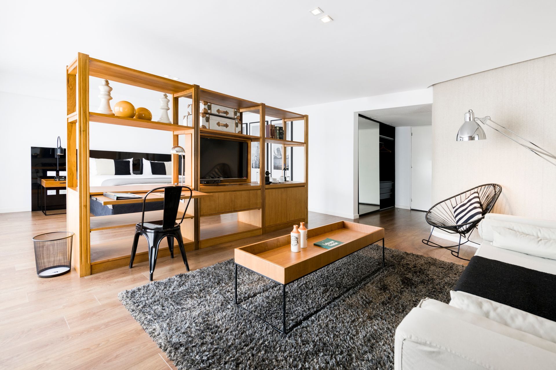 Una sala de estar con un sofá, sillas, una mesa de café y una televisión.